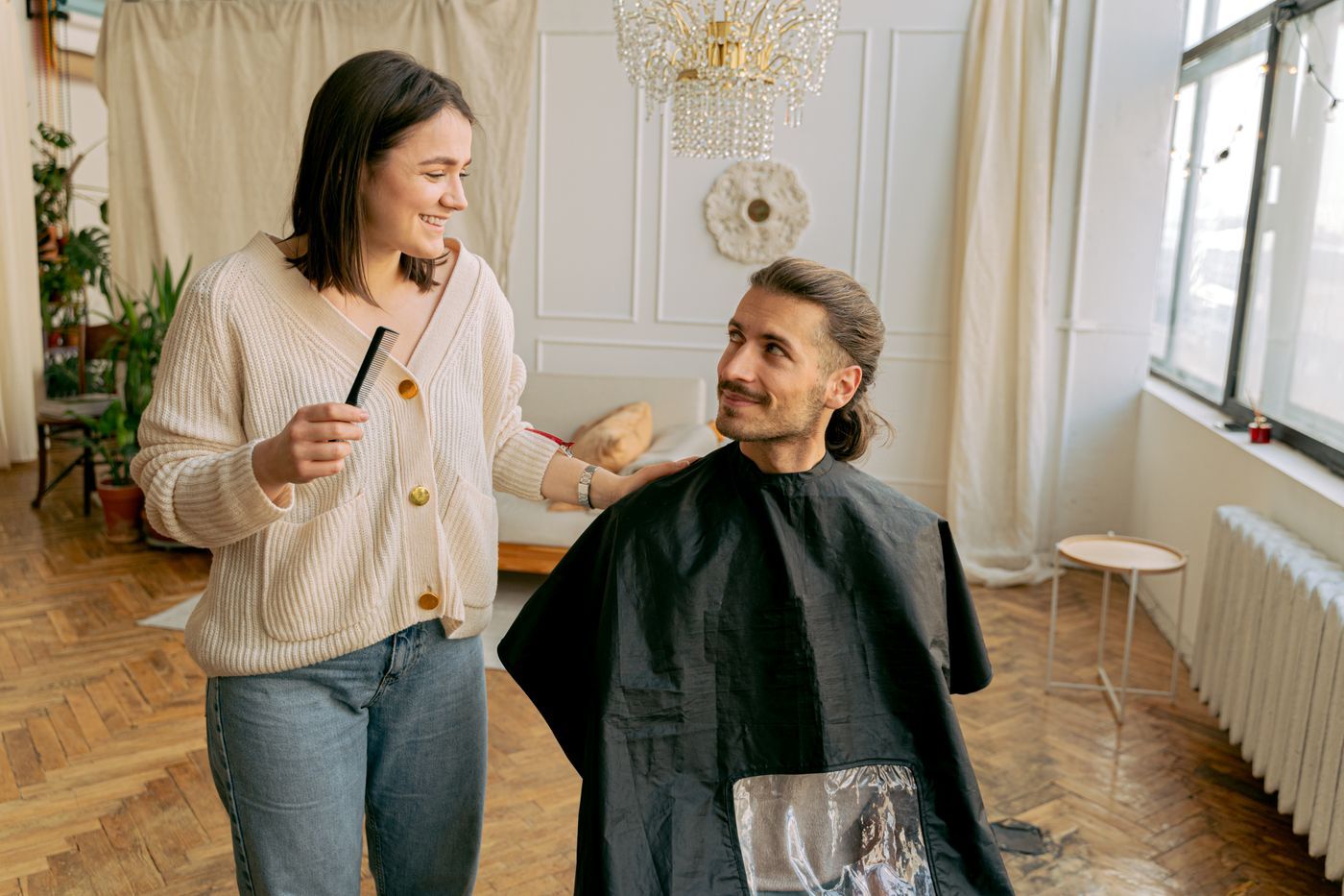 Ein Kunde und seine Dienstleisterin während eines Haarschnitts zu Hause