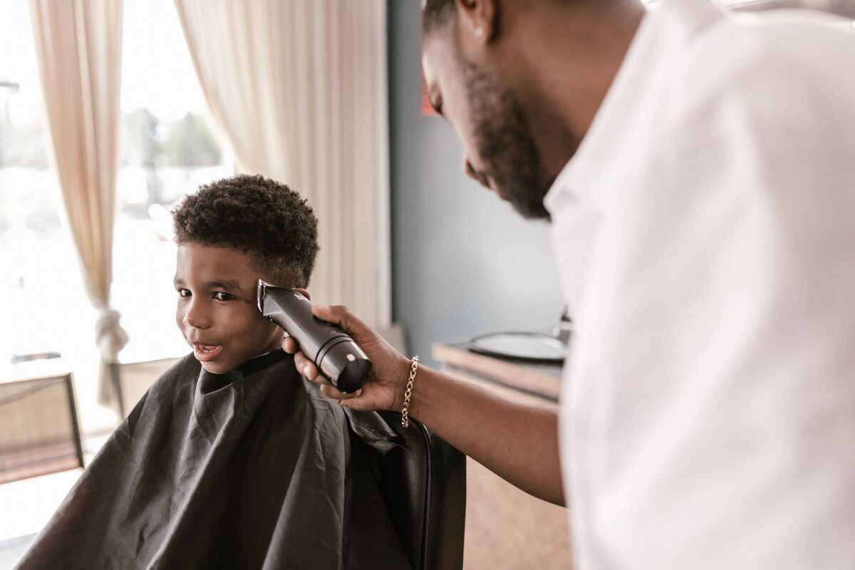 Corte a máquina para un niño, sentado junto a la ventana