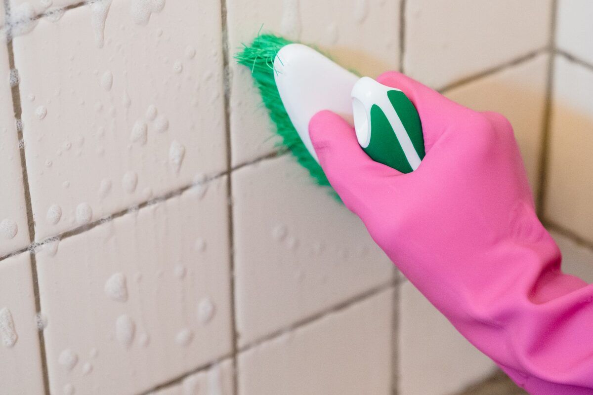 Tile grout being scrubbed with a brush during a deep clean