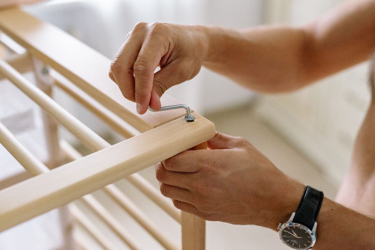 A wooden unit being assembled with an Allen key